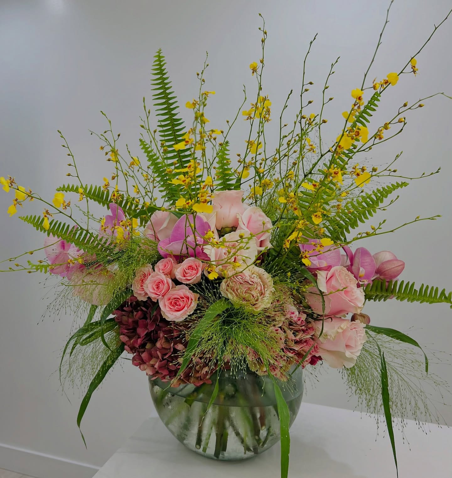 Pink roses, phalaenopsis and yellow oncidium orchids with antique hydrangea