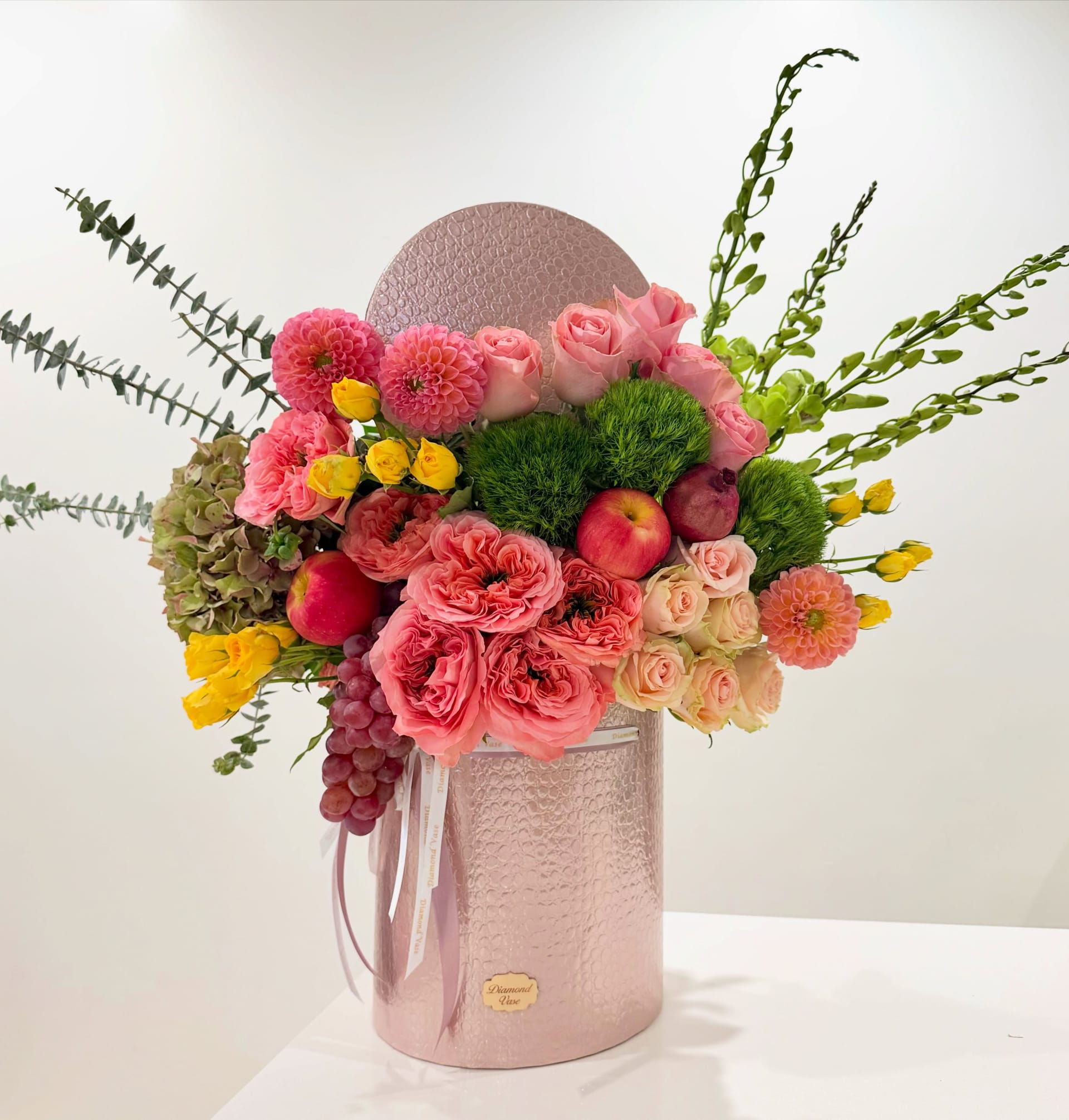 Rosh Hashanah box of coral-pink garden roses, pink dahlias and apples in a metallic pink Diamond Vase box